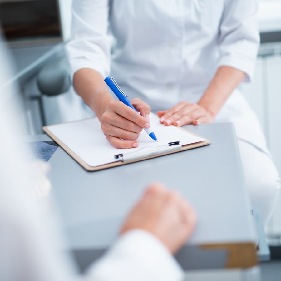 A woman and a team member fill out paperwork.